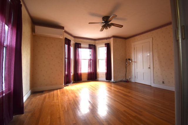 131 George St, Pittsfield, ME 04967 - empty room with ceiling fan, a wall mounted AC, wallpapered walls, and wood finished floors
