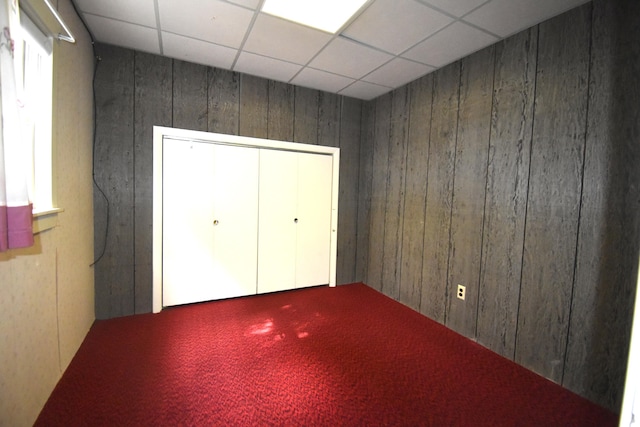 131 George St, Pittsfield, ME 04967 - unfurnished bedroom featuring wood walls, carpet, a closet, and a drop ceiling