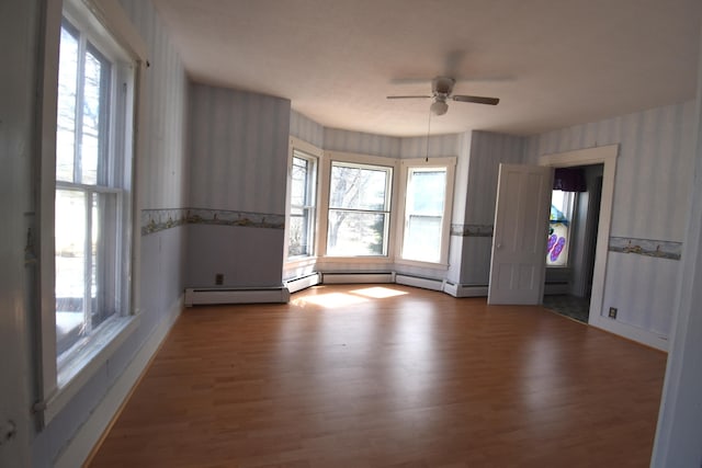 131 George St, Pittsfield, ME 04967 - empty room featuring ceiling fan, a baseboard radiator, wallpapered walls, and wood finished floors