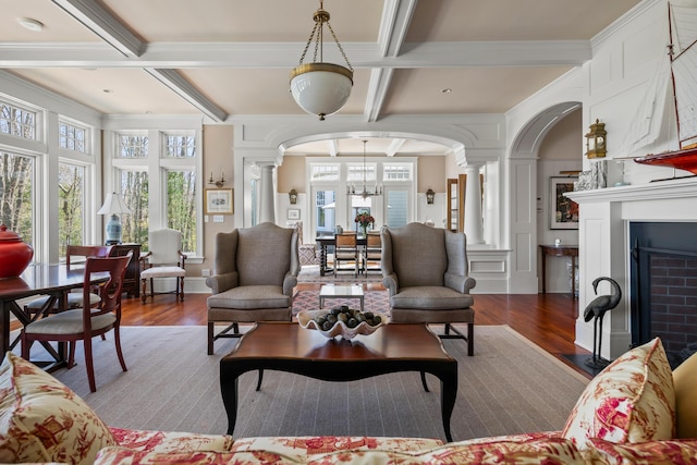 56 Deans Way, Cumberland, ME 04110 - living area featuring coffered ceiling, wood finished floors, arched walkways, beam ceiling, and ornate columns