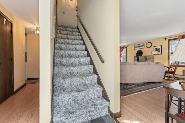 stairs with wood finished floors and baseboards