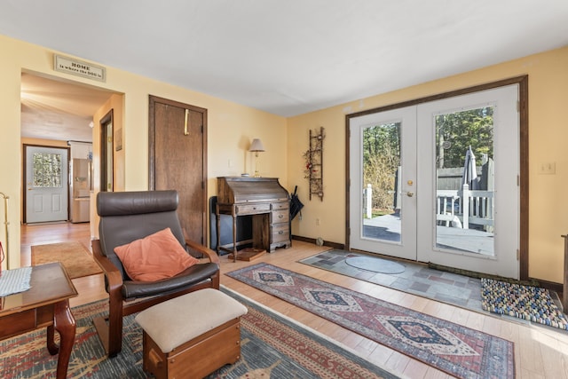 living room featuring wood finished floors, visible vents, baseboards, and french doors