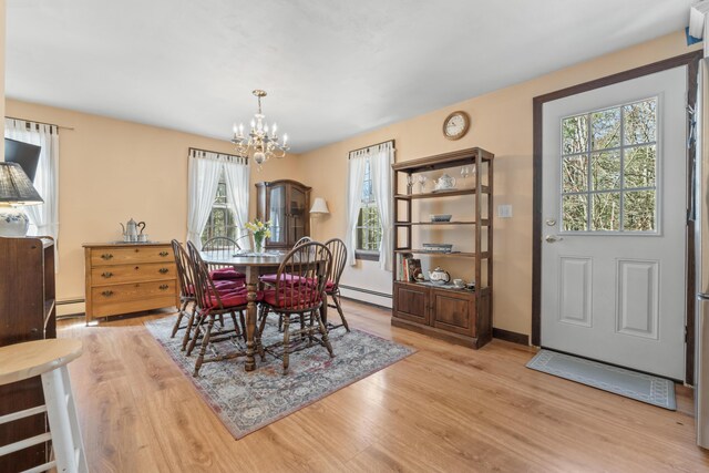 dining room with a baseboard radiator, a notable chandelier, and light wood-type flooring