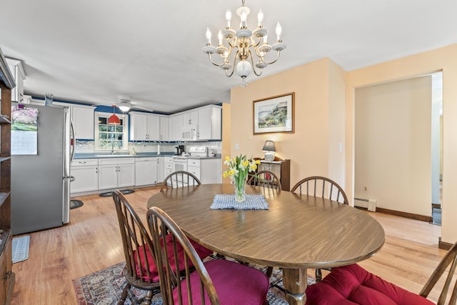 dining area featuring ceiling fan with notable chandelier, light wood-style flooring, and a baseboard radiator