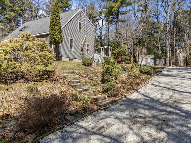 view of home's exterior featuring roof with shingles