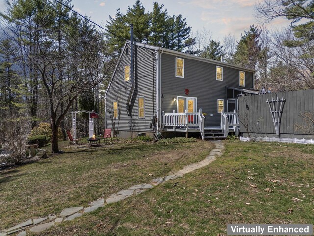 back of house with a lawn and a deck
