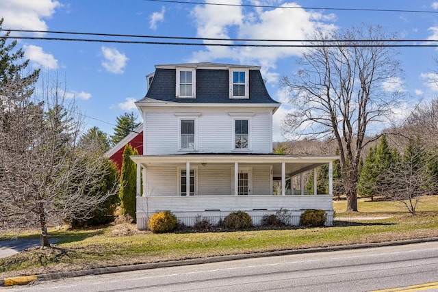 victorian home featuring covered porch, a shingled roof, a front lawn, and mansard roof