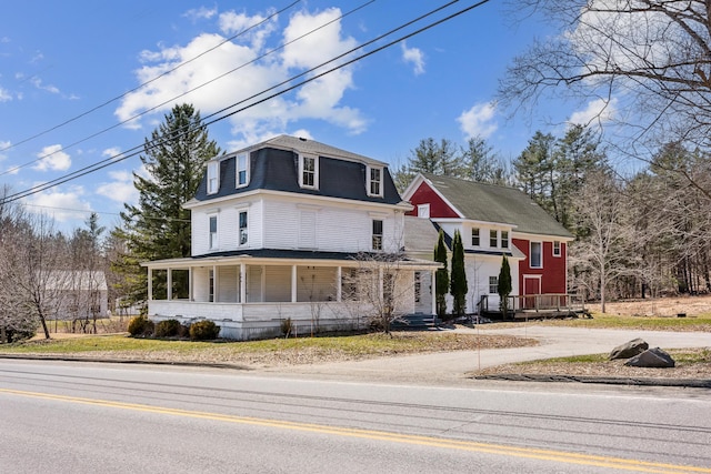 view of front of home featuring a porch and mansard roof