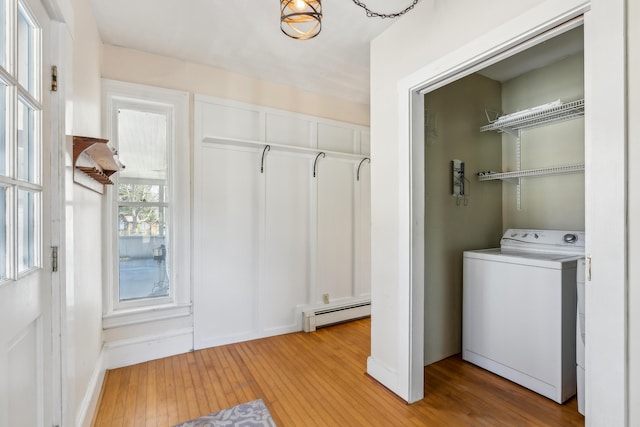 washroom featuring a baseboard heating unit, laundry area, light wood-style floors, and washer / dryer