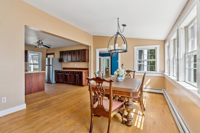 dining space featuring baseboard heating, a notable chandelier, light wood-type flooring, baseboards, and lofted ceiling