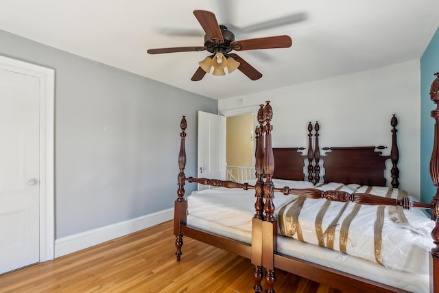 bedroom featuring a ceiling fan, baseboards, and light wood-style floors