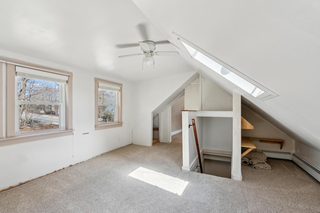 additional living space with a ceiling fan, lofted ceiling with skylight, and carpet