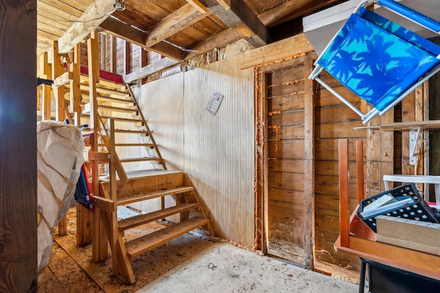 interior space with stairway and wooden walls
