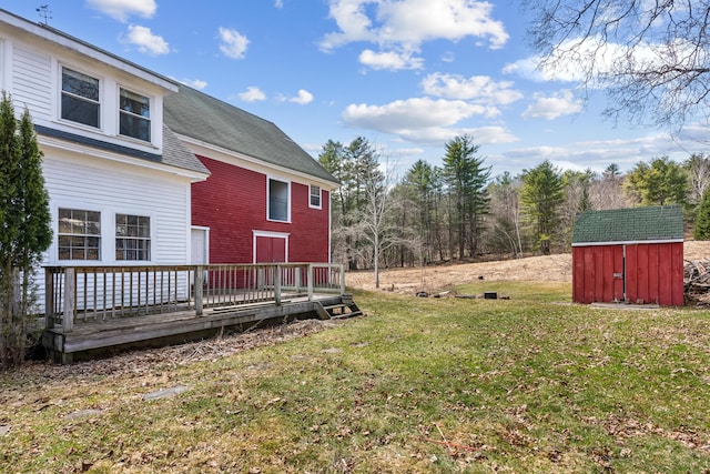 view of yard featuring a wooden deck, an outbuilding, and a storage shed