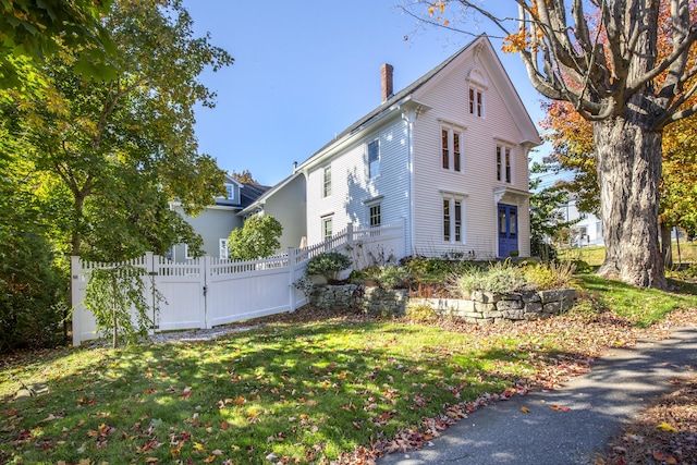40 Mountain St, Camden, ME 04843 - view of property exterior with a chimney, fence, and a lawn