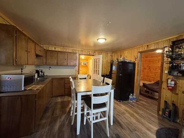 448 N Rd, Medford, ME 04463 - kitchen featuring a sink, wooden walls, stainless steel microwave, dark wood-style flooring, and freestanding refrigerator