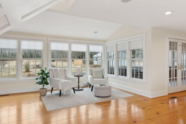sunroom featuring vaulted ceiling, french doors, wood-type flooring, baseboards, and visible vents