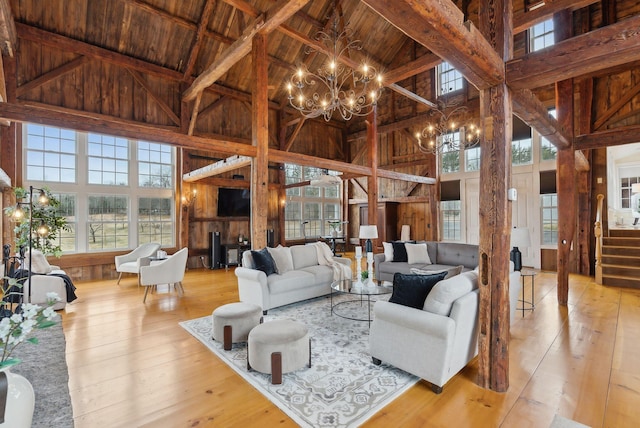 living room featuring wooden ceiling, hardwood / wood-style floors, high vaulted ceiling, and an inviting chandelier