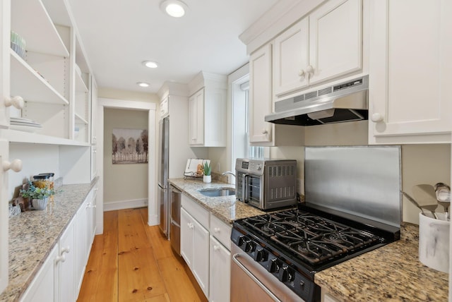 kitchen featuring range with gas cooktop, open shelves, a sink, white cabinetry, and under cabinet range hood