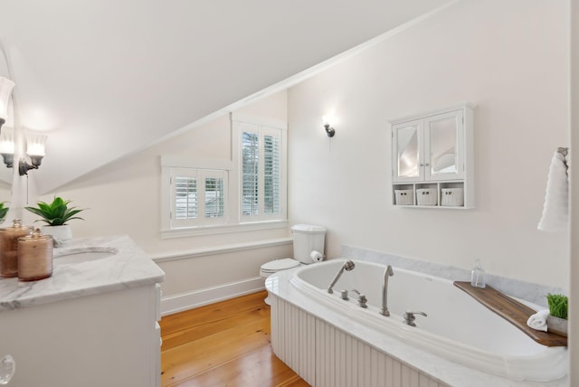 full bath featuring wood finished floors, toilet, vanity, a bath, and baseboards