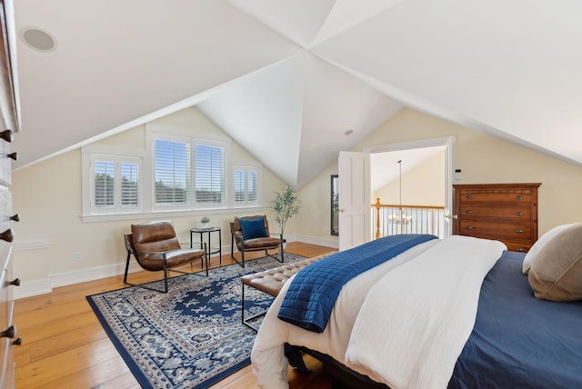 bedroom featuring lofted ceiling, hardwood / wood-style floors, and baseboards