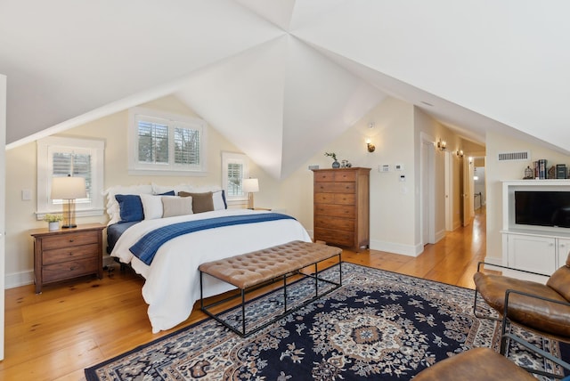bedroom featuring vaulted ceiling, visible vents, light wood finished floors, and baseboards