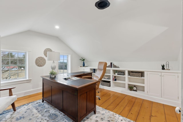home office with a wealth of natural light, baseboards, lofted ceiling, and light wood-type flooring