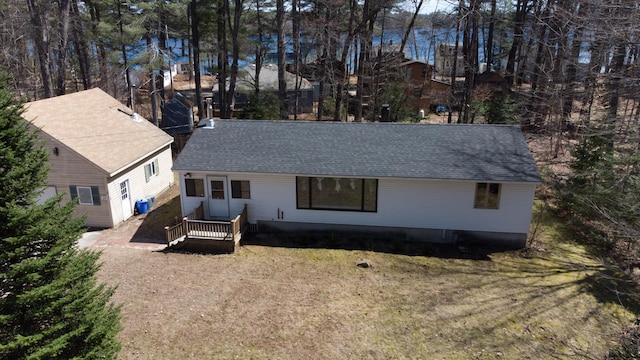 exterior space with roof with shingles, a yard, cooling unit, and a deck