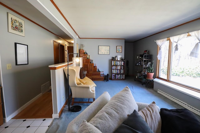 living room with a baseboard radiator, baseboards, crown molding, and visible vents