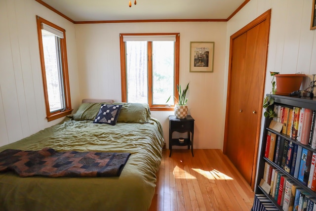bedroom featuring hardwood / wood-style flooring, a closet, and crown molding