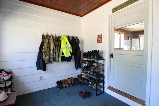 mudroom featuring wood ceiling, carpet floors, and wooden walls
