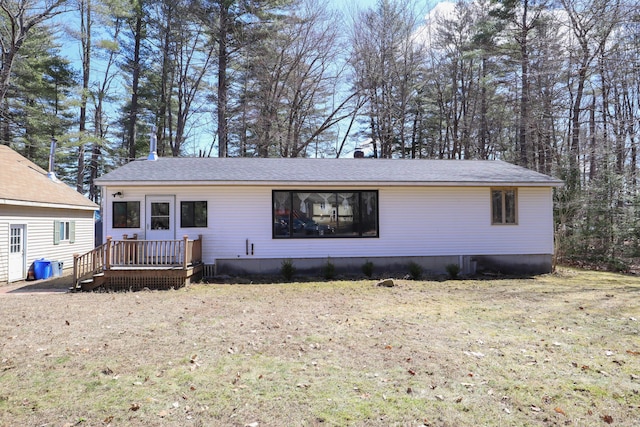 view of front facade with roof with shingles, a front lawn, and a deck