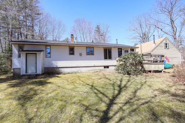 rear view of house with a lawn, a chimney, and a deck