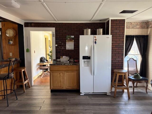 49 Pequawket Trl, Baldwin, ME 04024 - kitchen with dark countertops, white fridge with ice dispenser, brick wall, dark wood-style flooring, and visible vents