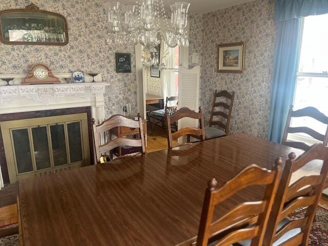 dining area featuring a wealth of natural light, a chandelier, and wallpapered walls