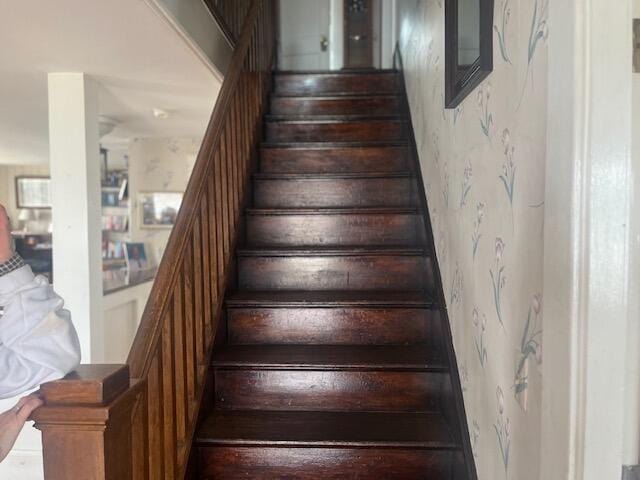 stairs featuring wallpapered walls