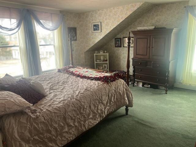 bedroom featuring multiple windows, wallpapered walls, and carpet