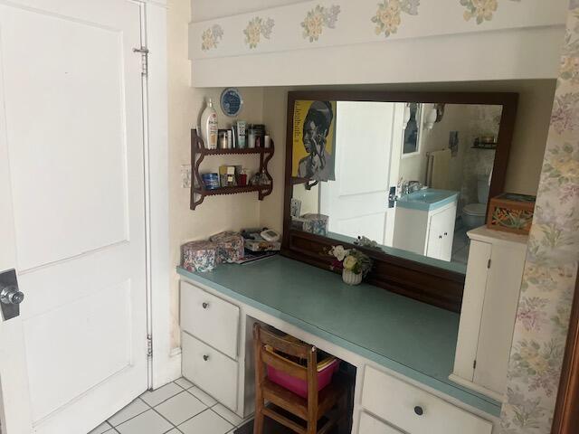 interior space featuring light tile patterned flooring, a sink, and built in desk