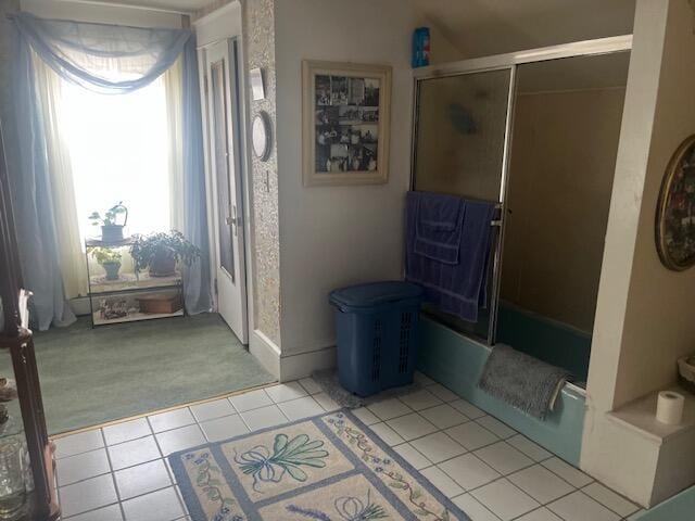 interior space with tile patterned flooring and shower / bath combination with glass door