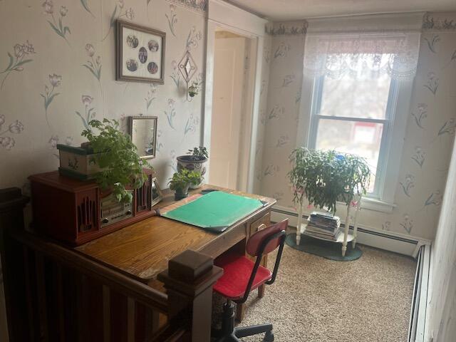 carpeted office space featuring a baseboard heating unit and wallpapered walls