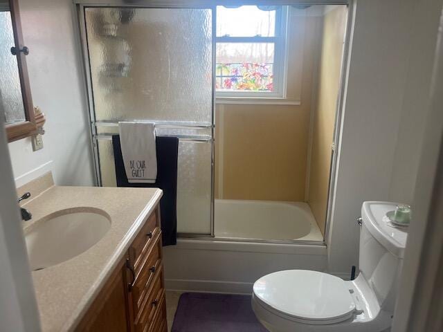 full bathroom featuring enclosed tub / shower combo, toilet, and vanity