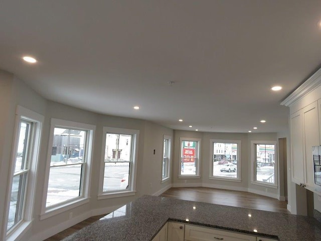 kitchen with dark stone countertops, baseboards, white cabinetry, and recessed lighting