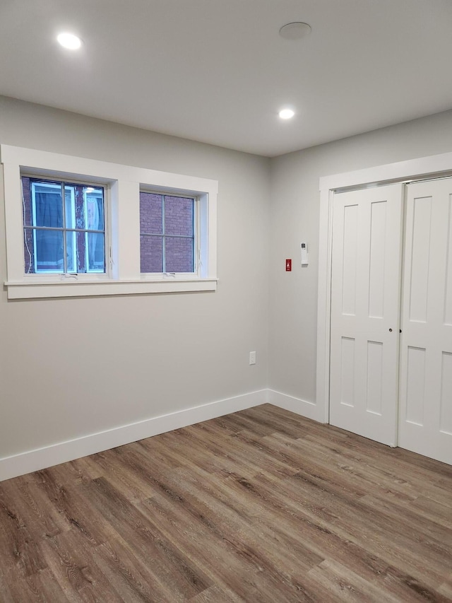interior space featuring recessed lighting, baseboards, and wood finished floors