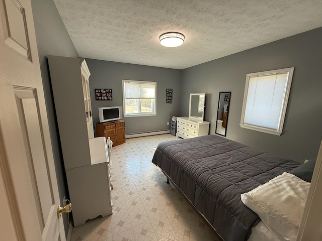 182 E Main St, Fort Kent, ME 04743 - bedroom featuring light floors, a baseboard radiator, baseboards, and a textured ceiling