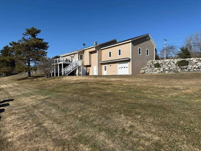 182 E Main St, Fort Kent, ME 04743 - back of property with a garage, stairs, a deck, and a yard