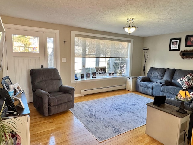 182 E Main St, Fort Kent, ME 04743 - living room featuring a baseboard radiator, light wood finished floors, and a textured ceiling