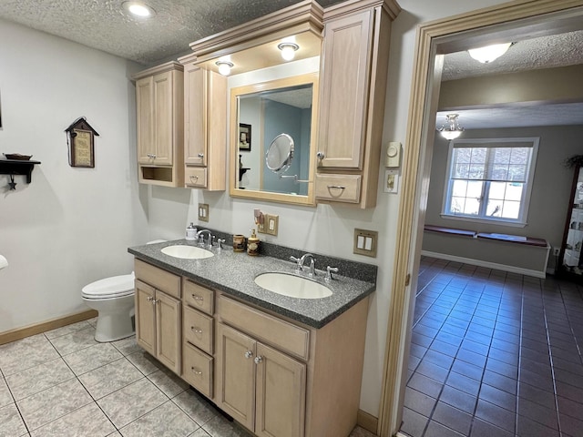 182 E Main St, Fort Kent, ME 04743 - bathroom with a textured ceiling, tile patterned floors, baseboards, toilet, and double vanity