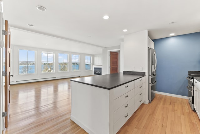 6 Merritt House Rd Unit 20, Harpswell, ME 04066 - kitchen featuring dark countertops, light wood-type flooring, open floor plan, a peninsula, and recessed lighting
