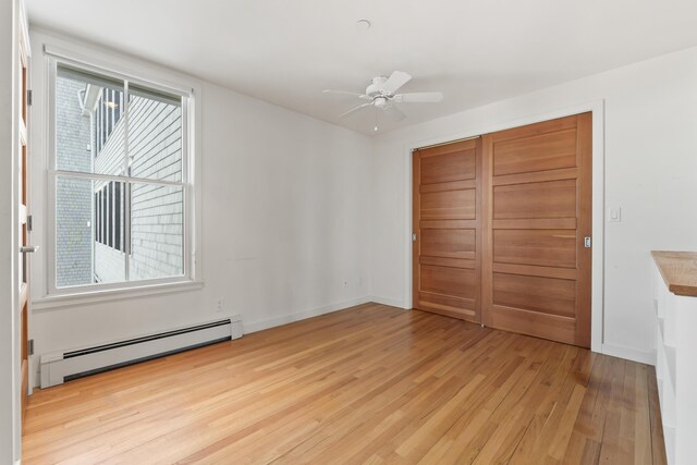6 Merritt House Rd Unit 20, Harpswell, ME 04066 - unfurnished bedroom featuring a baseboard heating unit, light wood finished floors, a closet, and baseboards
