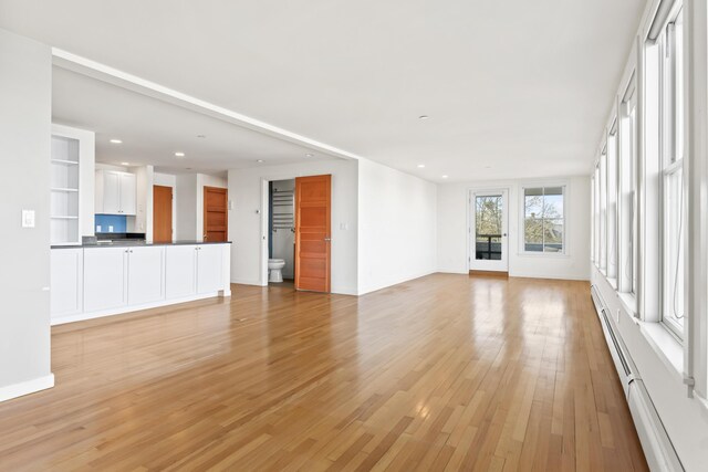 6 Merritt House Rd Unit 20, Harpswell, ME 04066 - unfurnished living room featuring a baseboard radiator, light wood finished floors, recessed lighting, and baseboards